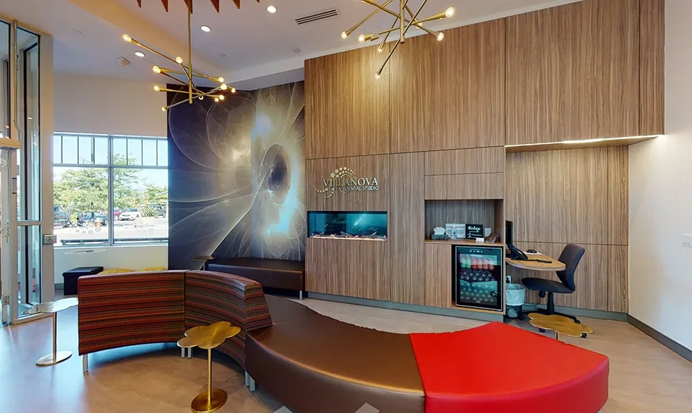 The Main Street reception lounge with a wood feature wall, red sofa, aquarium and chandelier